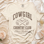 Cream t-shirt featuring brown text reading COWGIRL COUNTRY CLUB above Olivia's Bachelorette Franklin, TN.