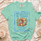 Retro t-shirt with "Reckless in Texas" and cowboy boot graphic.