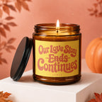 Amber jar candle with "Our Love Story Ends Continues" text and "vowed" logo.