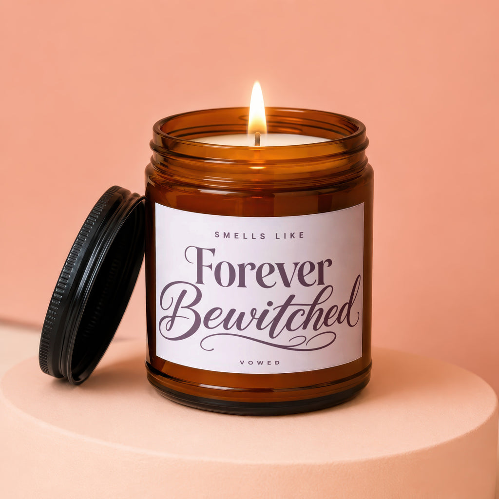 Amber jar candle labeled "Smells Like Forever Bewitched" with lid off.