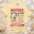 Yellow t-shirt with "Mother of the bride I raised her NOT A VICTIM" text and spooky ghost graphic.