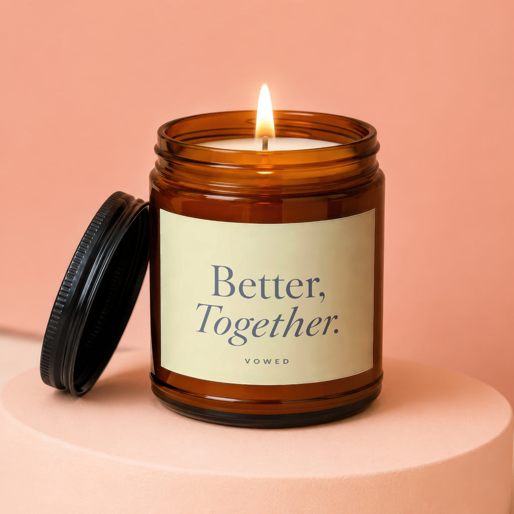 Amber jar candle with lit flame and lid off, reads "Better, Together."