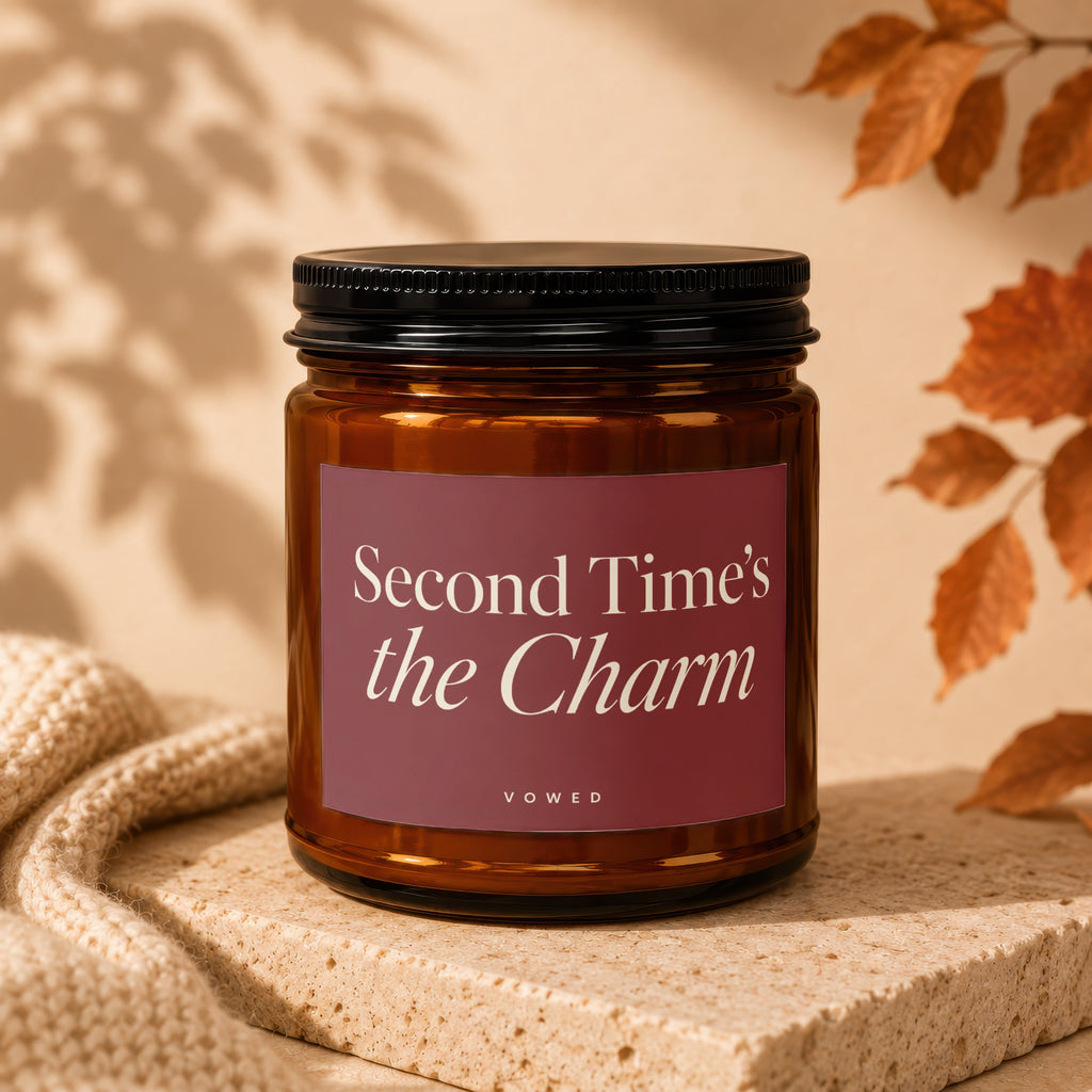 Amber jar candle with maroon label that reads "Second Time's the Charm" and "VOWED".