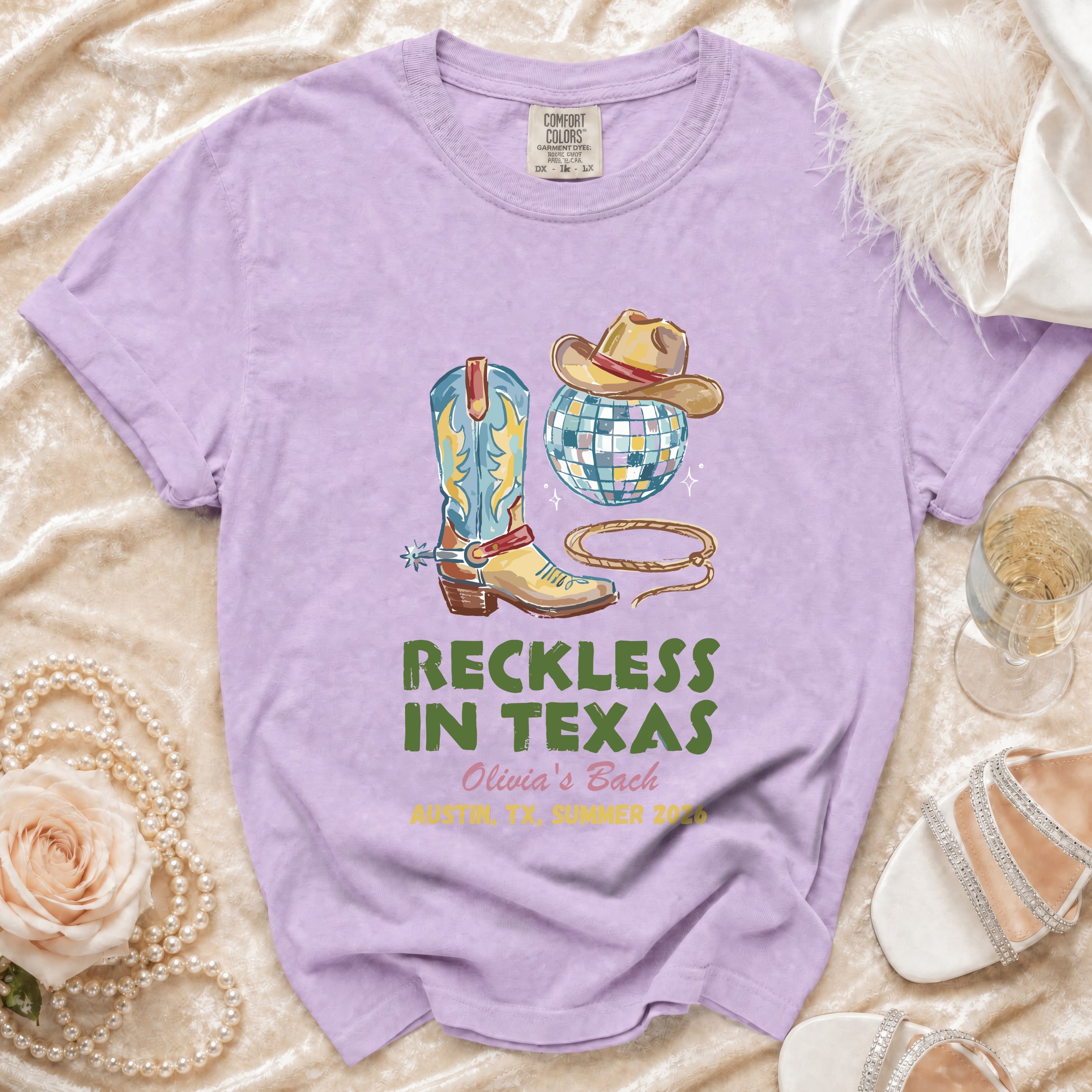 Purple t-shirt with cowboy boots, hat, disco ball, and text.