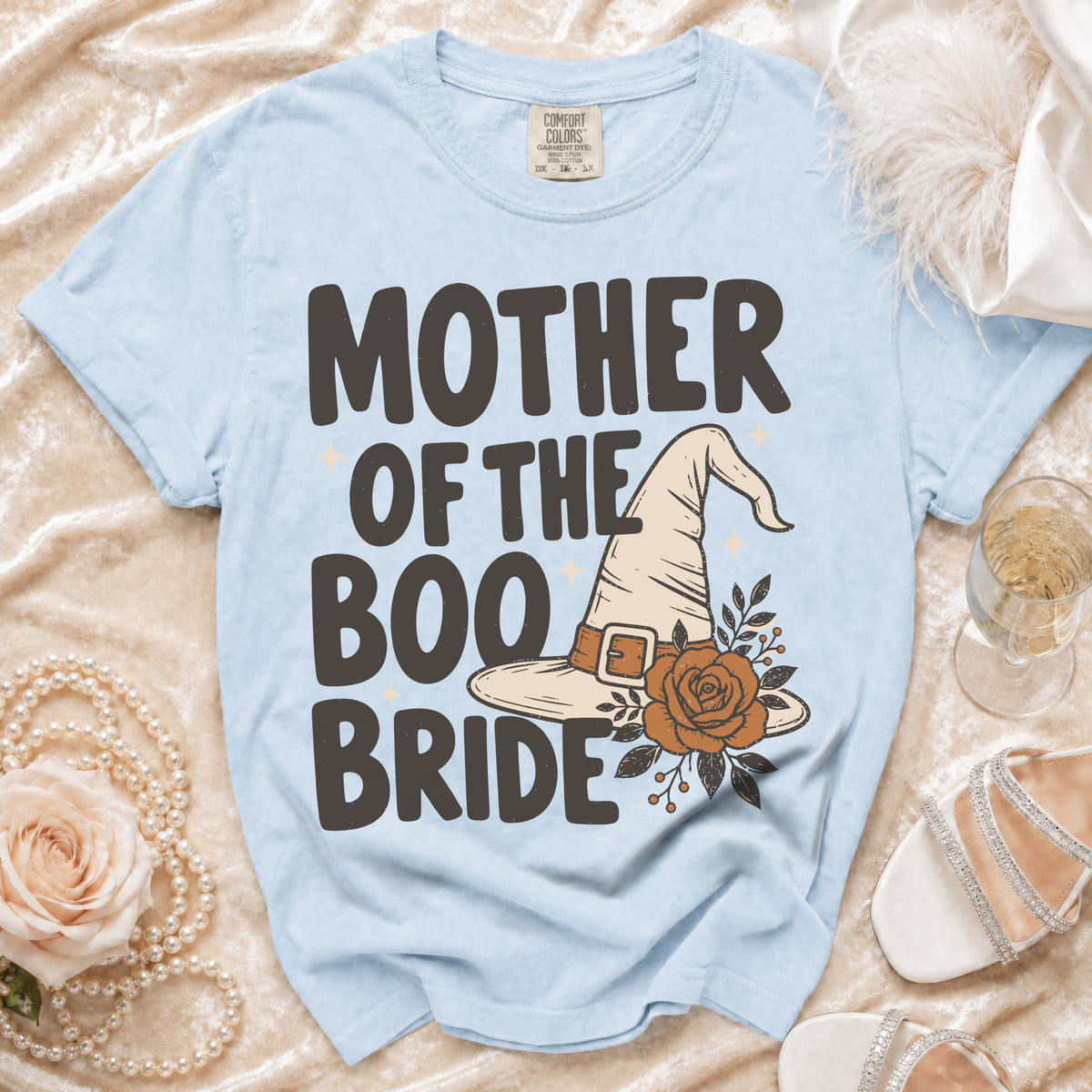 Light blue t-shirt with "MOTHER OF THE BOO BRIDE" text and witch hat graphic.