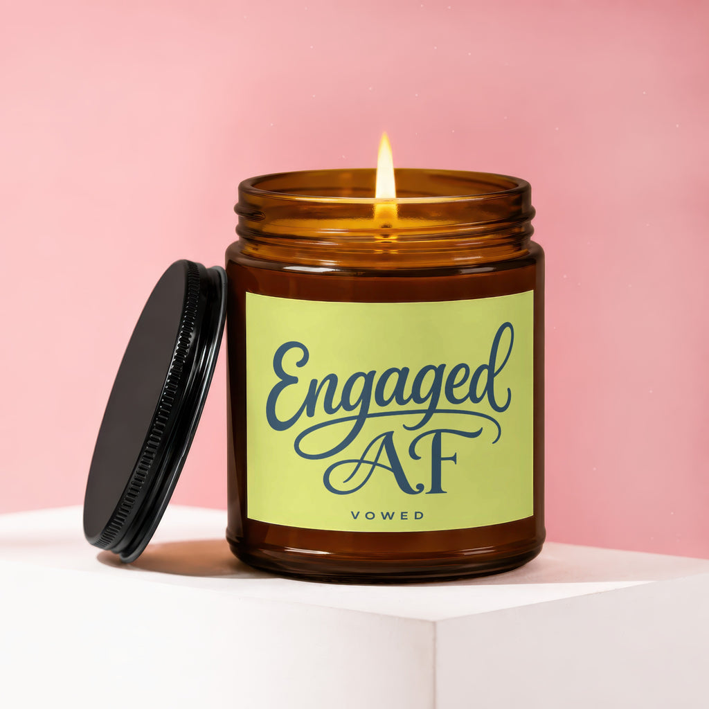 Amber jar candle with lit wick and "Engaged AF VOWED" text on a light green label.