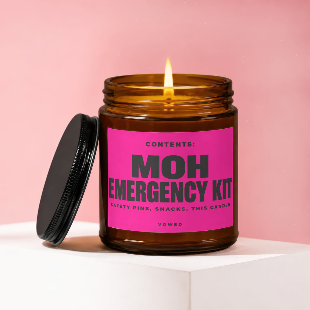 Amber jar candle with lit flame and "MOH Emergency Kit" label.