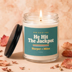 Candle with "He Hit The Jackpot" and "Harper + Miles" text, lid off.