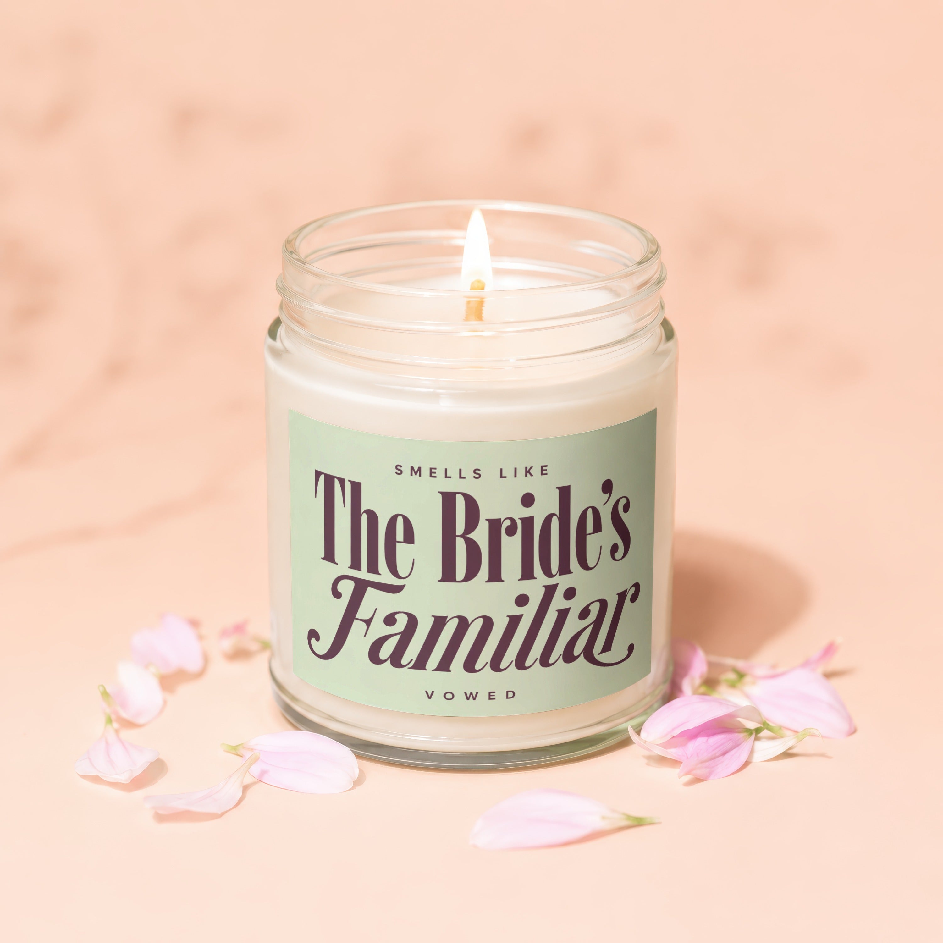 Candle with label that reads "Smells Like The Bride's Familiar Vowed", surrounded by petals.