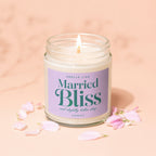 Lit jar candle with "Married Bliss and slightly better sleep" text surrounded by petals.