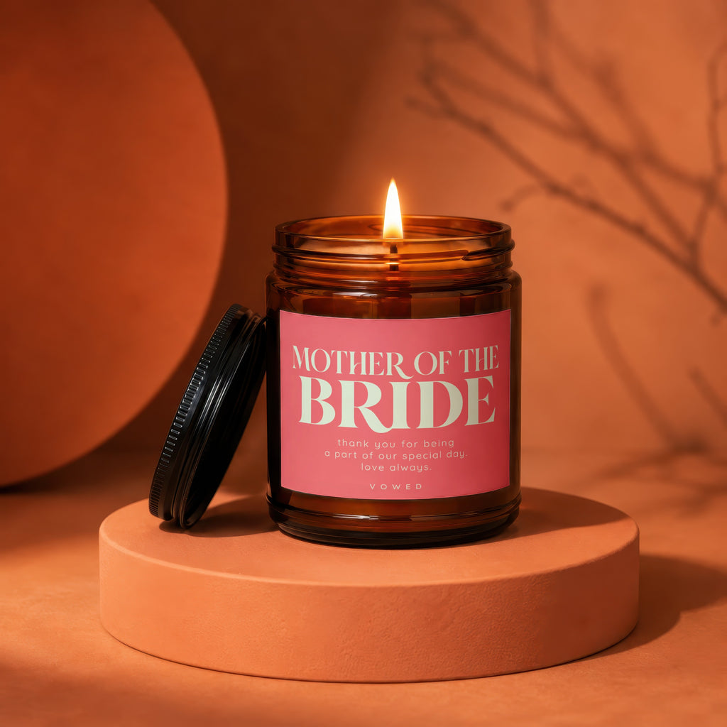 Amber jar candle with lit flame, reads "Mother of the Bride".
