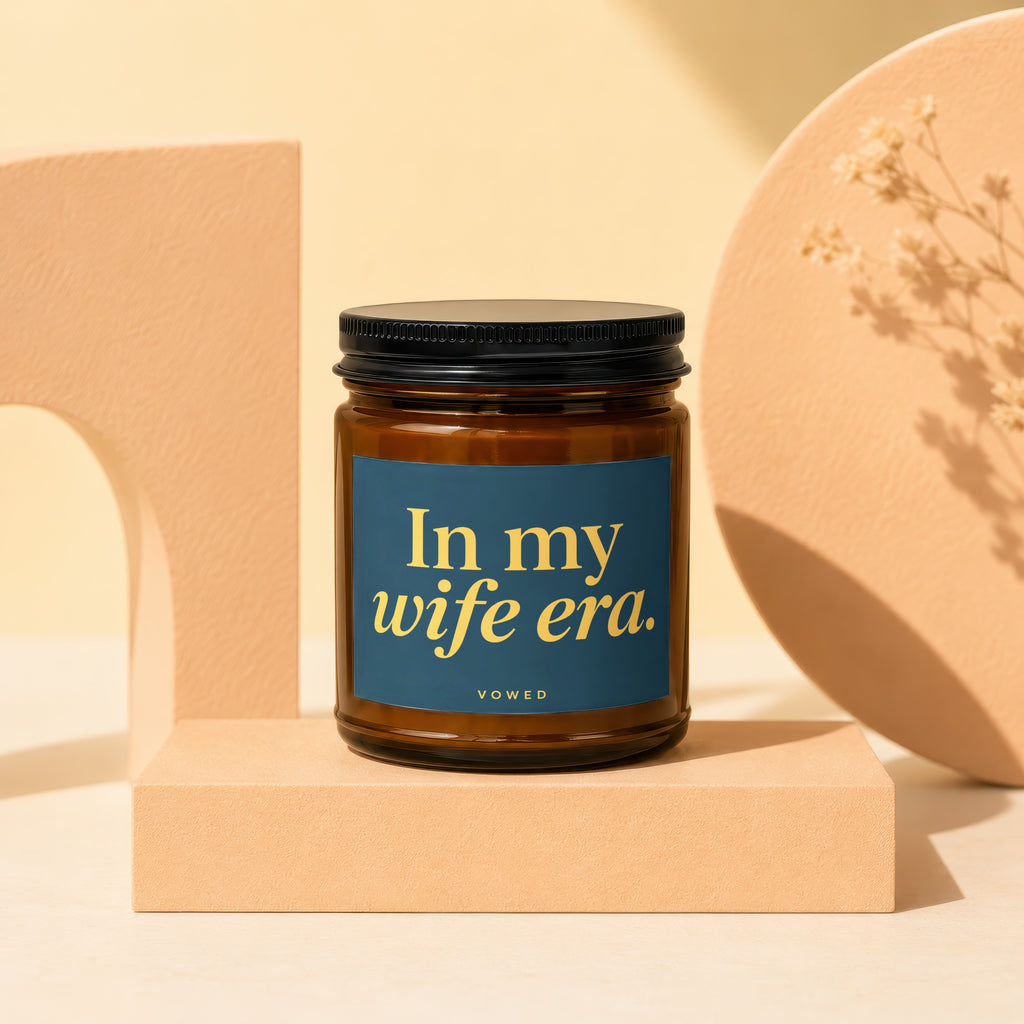 Brown glass candle with dark lid and navy label reading "In my wife era."