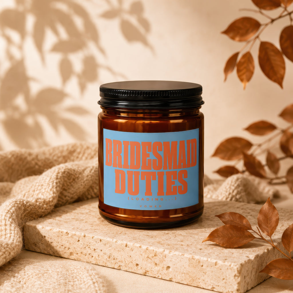 Amber jar candle with label reading "BRIDESMAID DUTIES (LOADING...) VOWED".