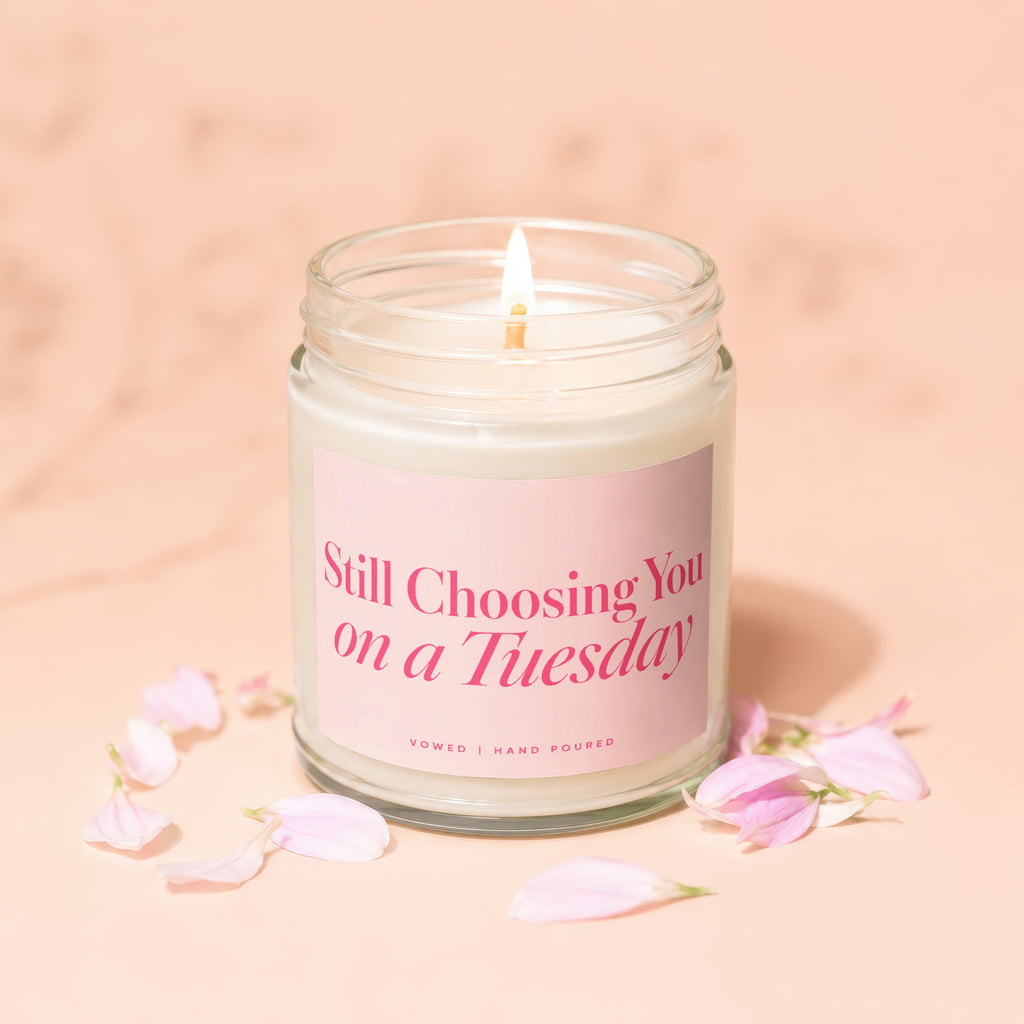 Glass jar candle with pink label reading "Still Choosing You on a Tuesday".