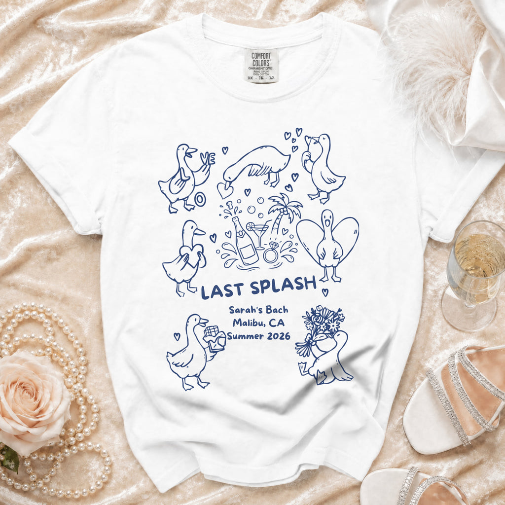 White t-shirt with blue cartoon ducks, "Last Splash", and event details.