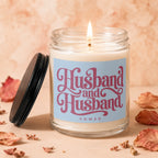 Jar candle with lit wick, reads "Husband and Husband Vowed" on label.