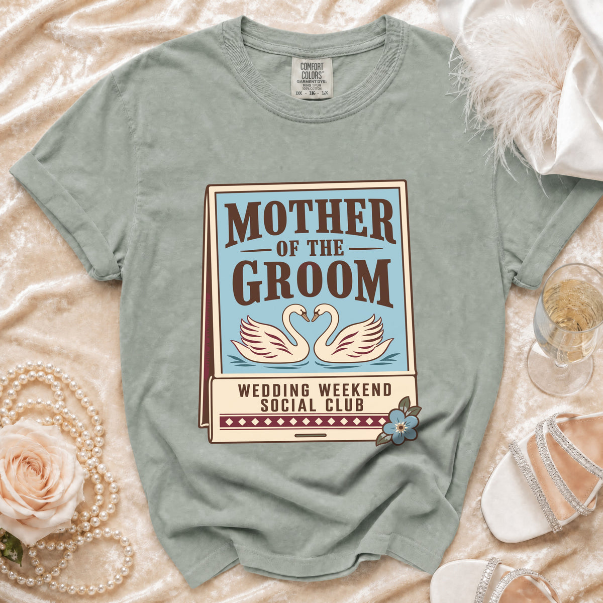 Sage green t-shirt with "Mother of the Groom Wedding Weekend Social Club" graphic.