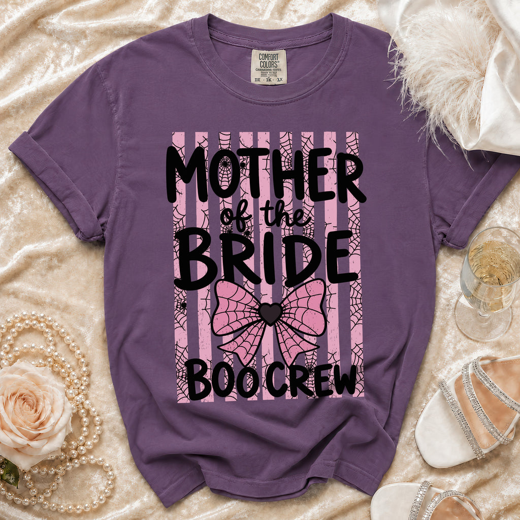 Purple t-shirt featuring the text Mother of the Bride Boo Crew over pink stripes and spiderwebs.