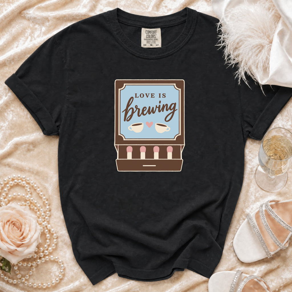 Black t-shirt with "Love is Brewing" text and coffee cup graphic.
