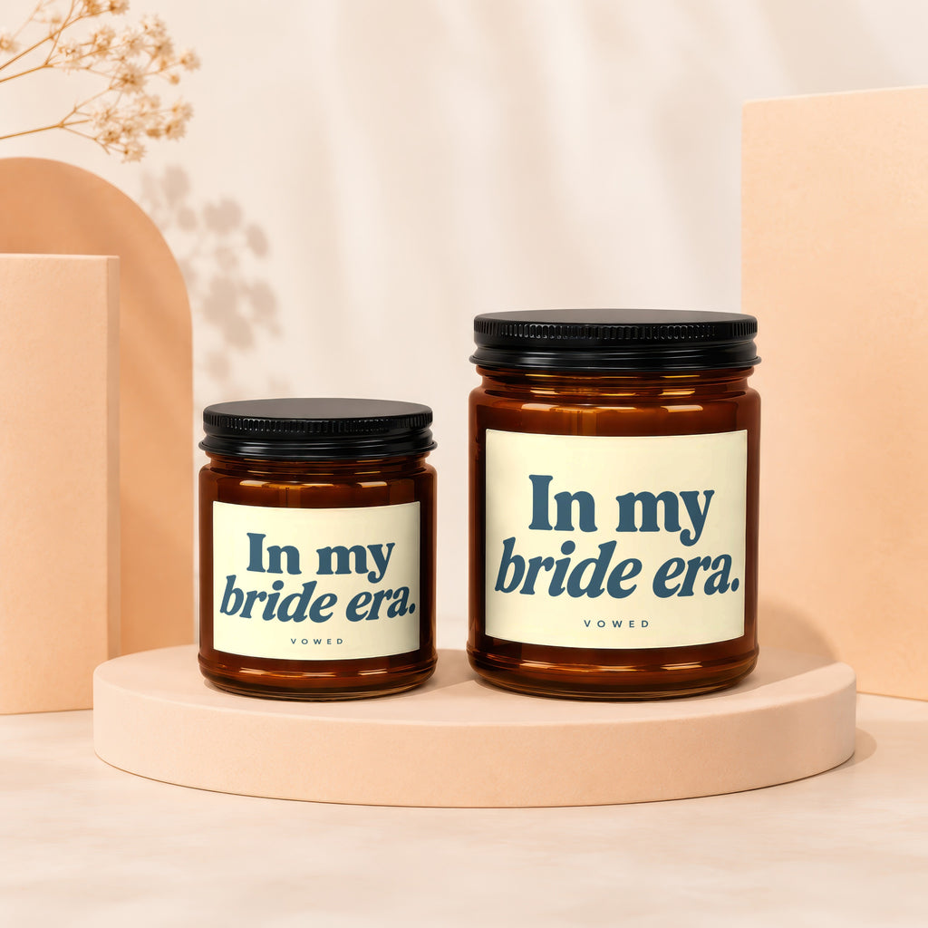 Two glass candles with black lids, one smaller than the other, both labeled "In my bride era."