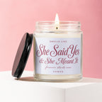 Candle in a jar with lit wick and text "She Said Yes & She Meant It".