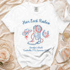White t-shirt with "Her Last Rodeo" cowboy boot, hat, horseshoe, and event details.
