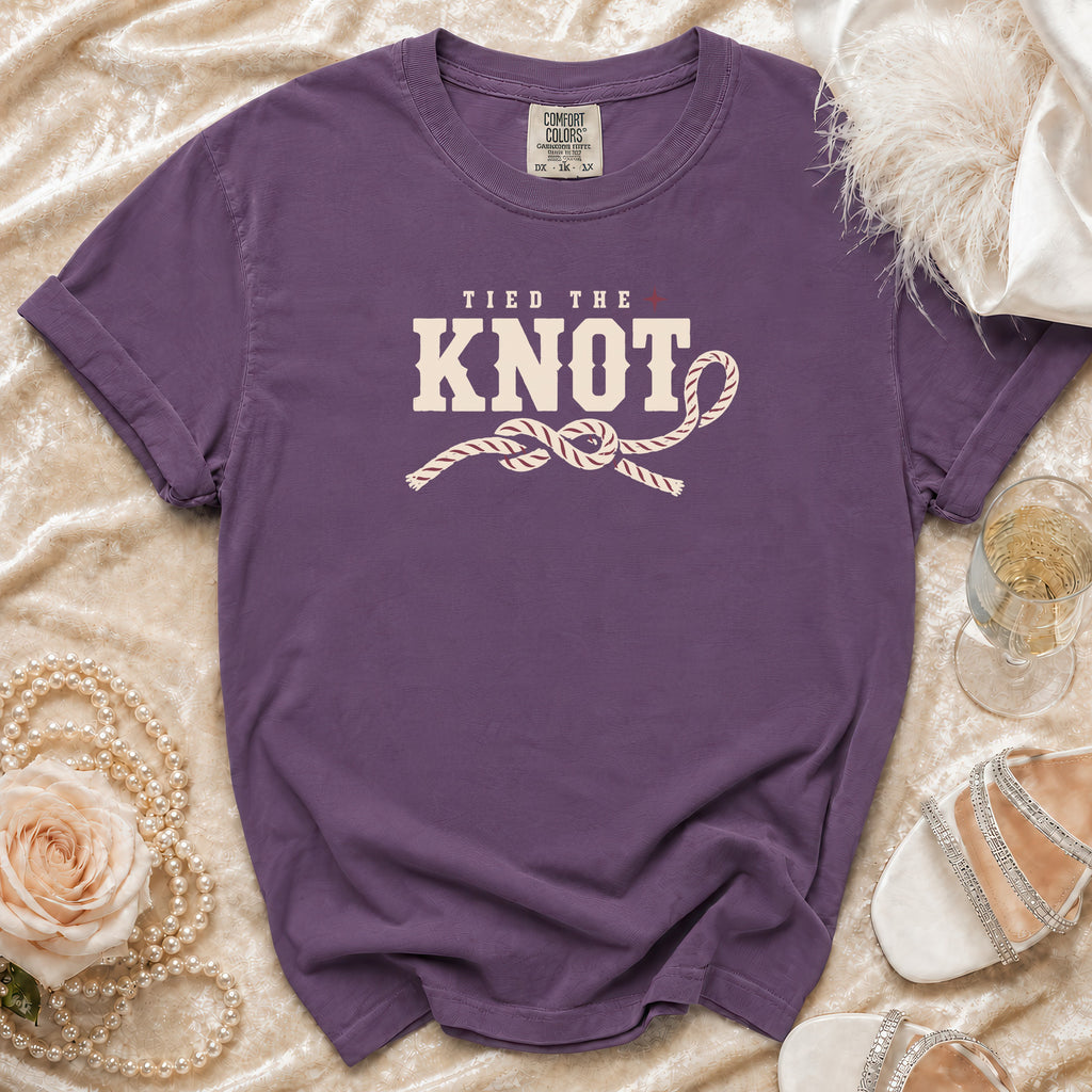 Purple t-shirt with "Tied the Knot" text and rope knot graphic.