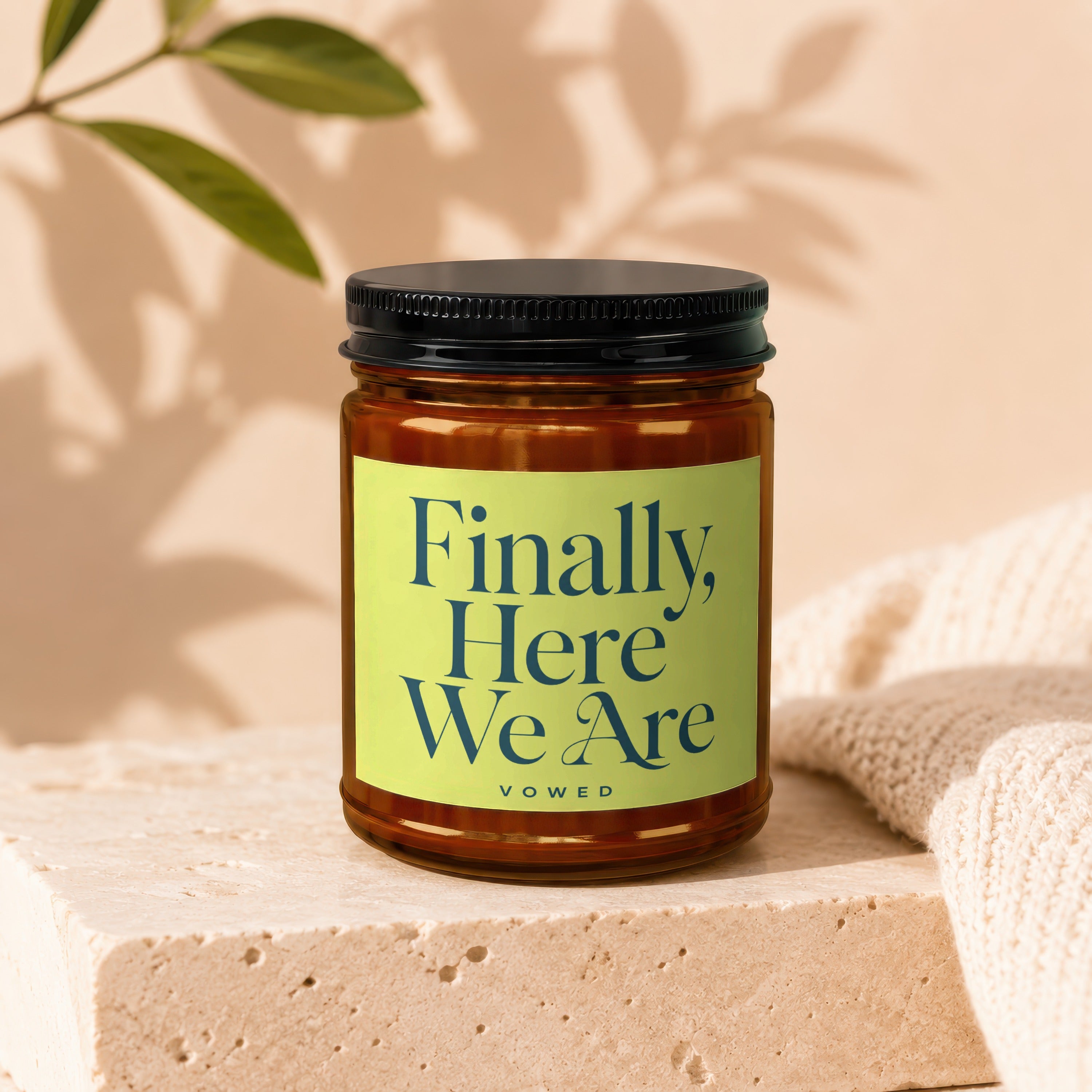 Amber candle in glass jar with "Finally, Here We Are" label and "vowed" text.
