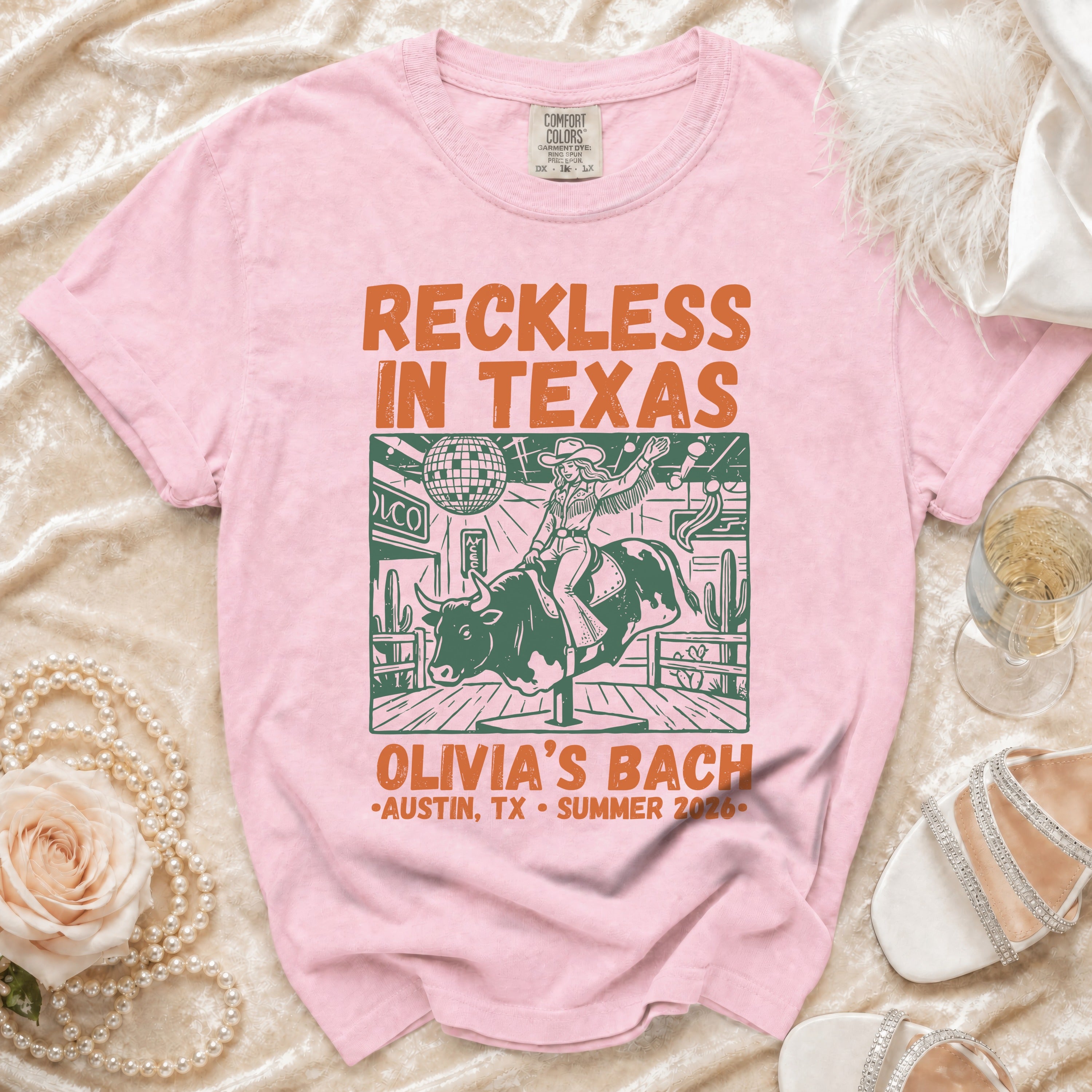 Pink t-shirt with "Reckless in Texas" and "Olivia's Bach" text.