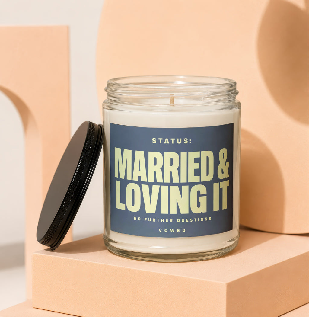 Glass candle with navy label reading "Status: Married & Loving It".