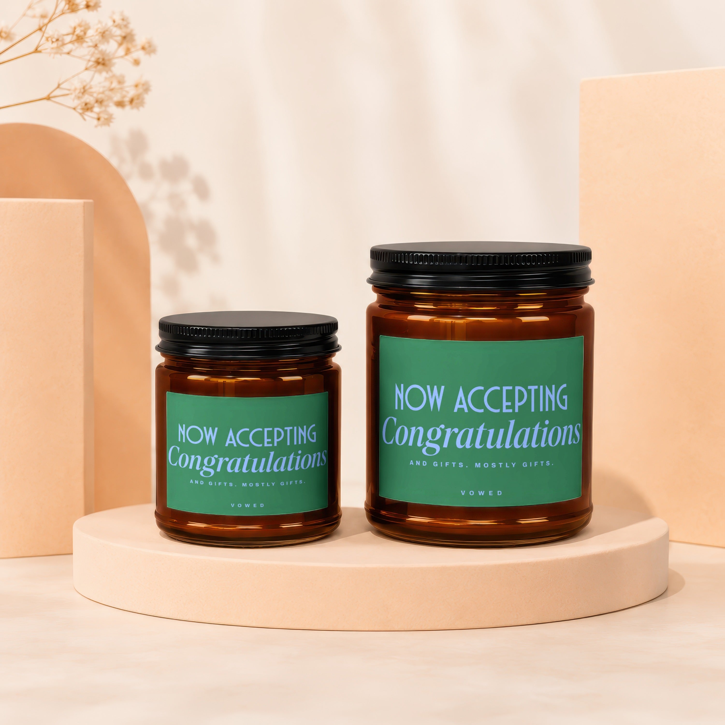 Amber glass candles with green labels reading "Now Accepting Congratulations And Gifts."
