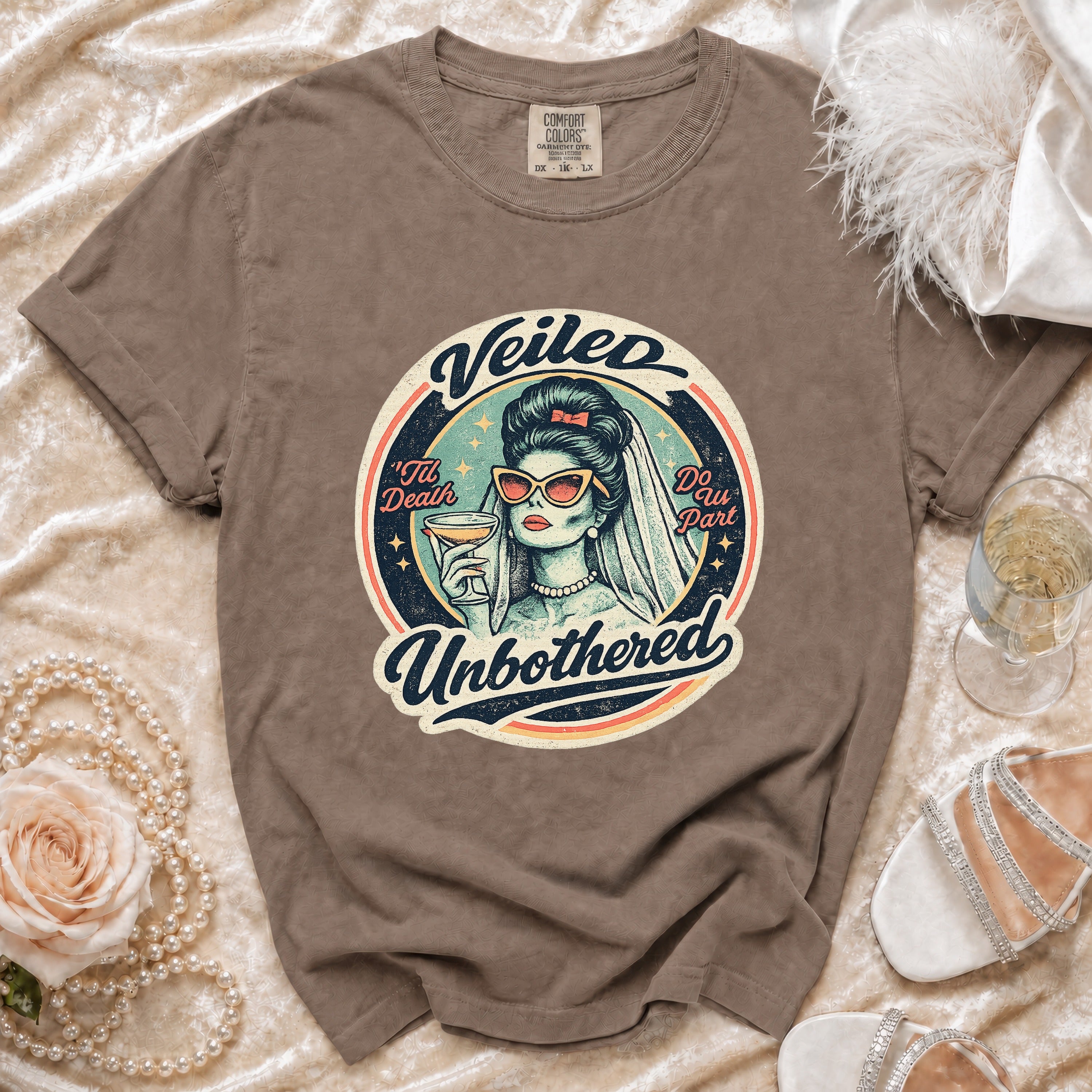 Brown t-shirt with "Veiled Unbothered" graphic of a bride holding a drink.