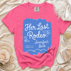 Pink t-shirt with "Her Last Rodeo" text, cowboy boots, and hat.