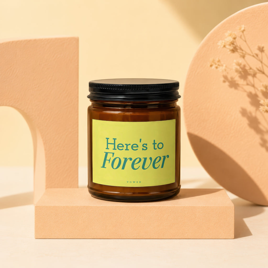 Amber candle with "Here's to Forever" text on a light green label.