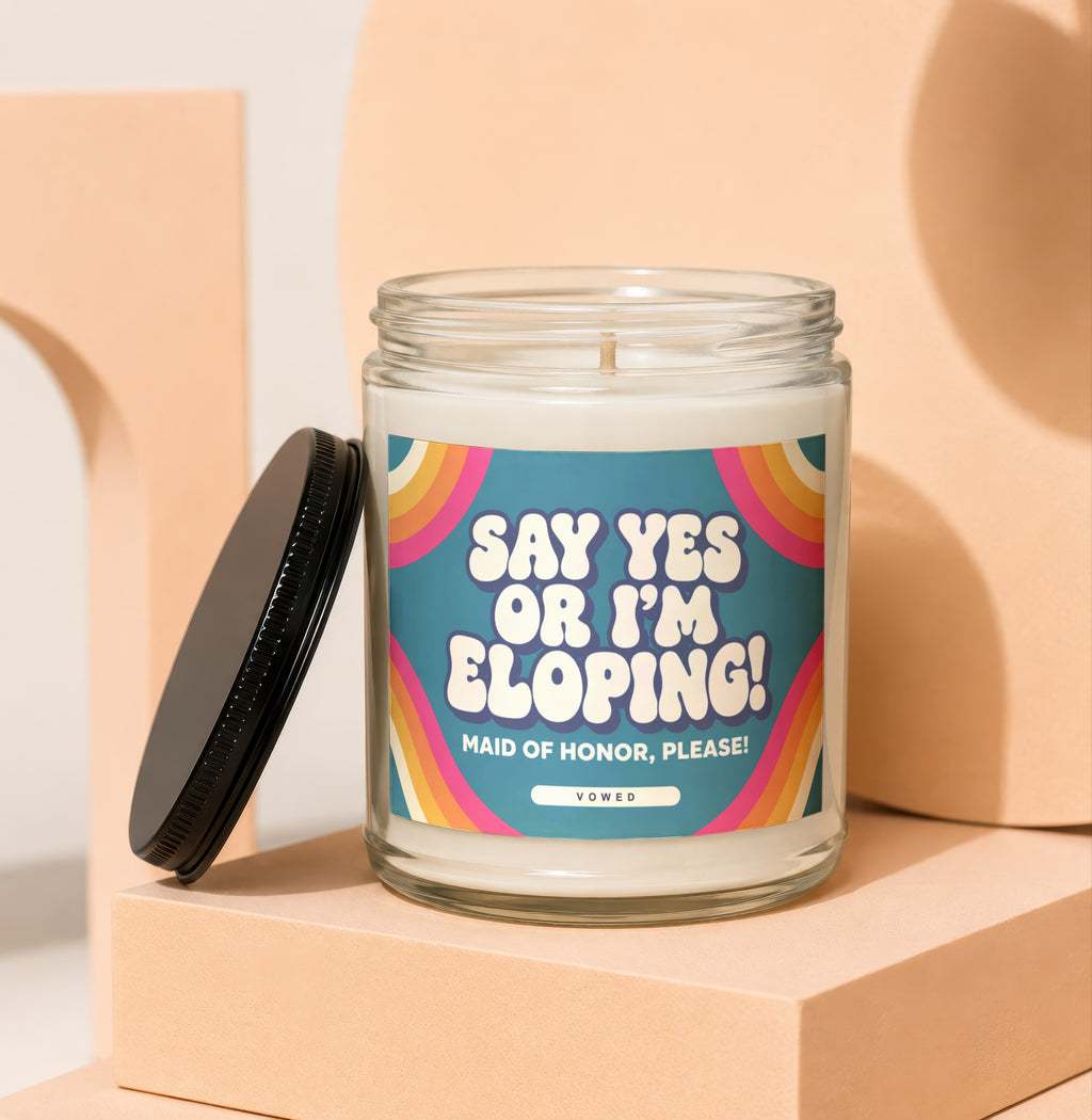 Candle with "Say Yes or I'm Eloping! Maid of Honor, Please!" text on label.