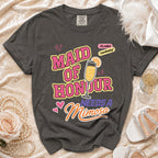 Dark grey t-shirt with "Maid of Honour Needs a Mimosa" graphic.