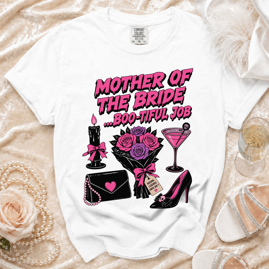 A white t-shirt featuring pink text that reads Mother of the Bride ... Boo-Tiful Job, surrounded by gothic-style illustrations.