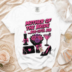 A white t-shirt featuring pink text that reads Mother of the Bride ... Boo-Tiful Job, surrounded by gothic-style illustrations.