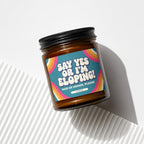 Amber jar candle with "Say Yes Or I'm Eloping!" text and rainbow design.