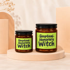Two glass jars with black lids and "Skeptical Honorary Witch Vowed" labels.