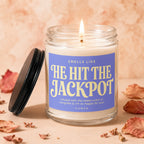 Candle with purple label reading "Smells Like He Hit The Jackpot"