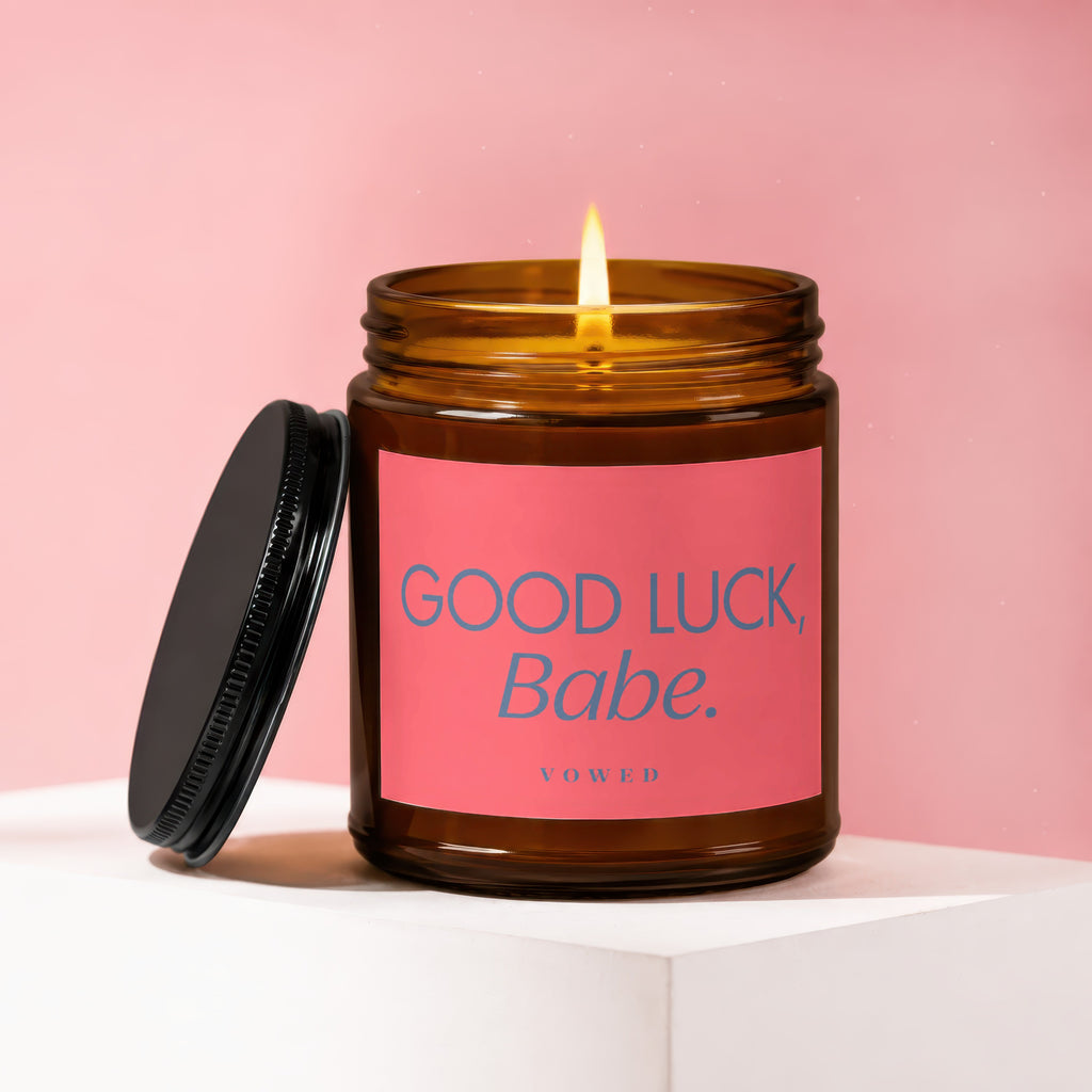 Amber jar candle with pink label reading "GOOD LUCK, Babe."