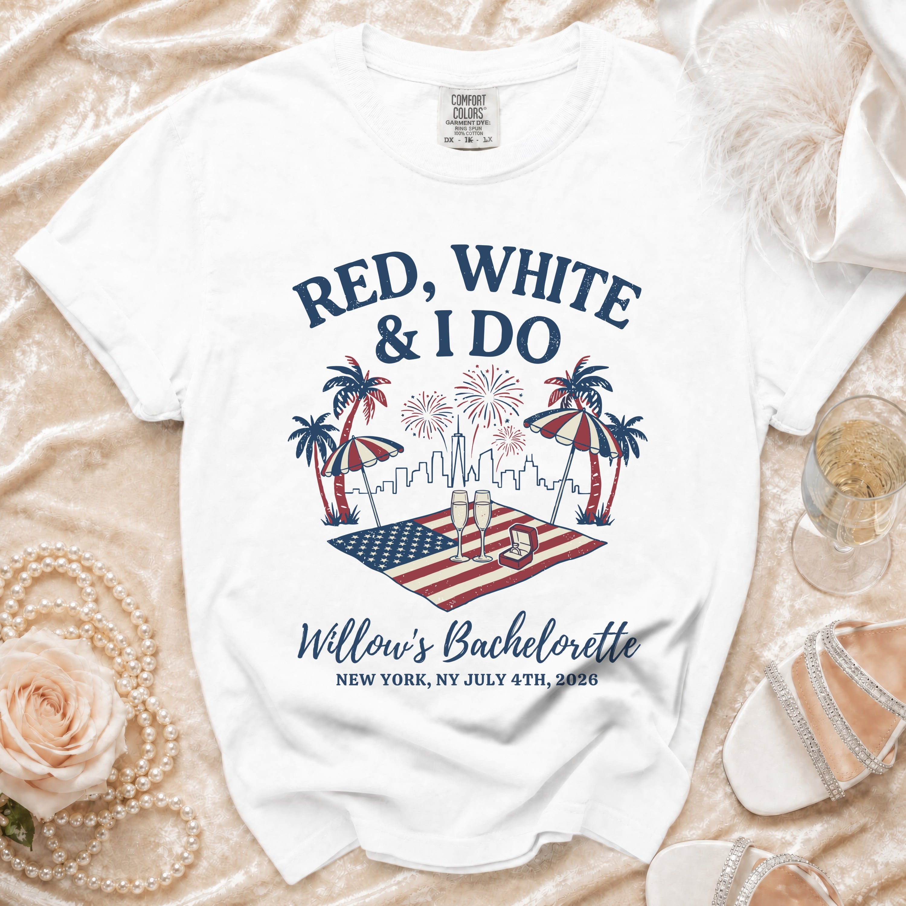 White t-shirt with "Red, White & I Do" text, American flag, fireworks, and palm trees.