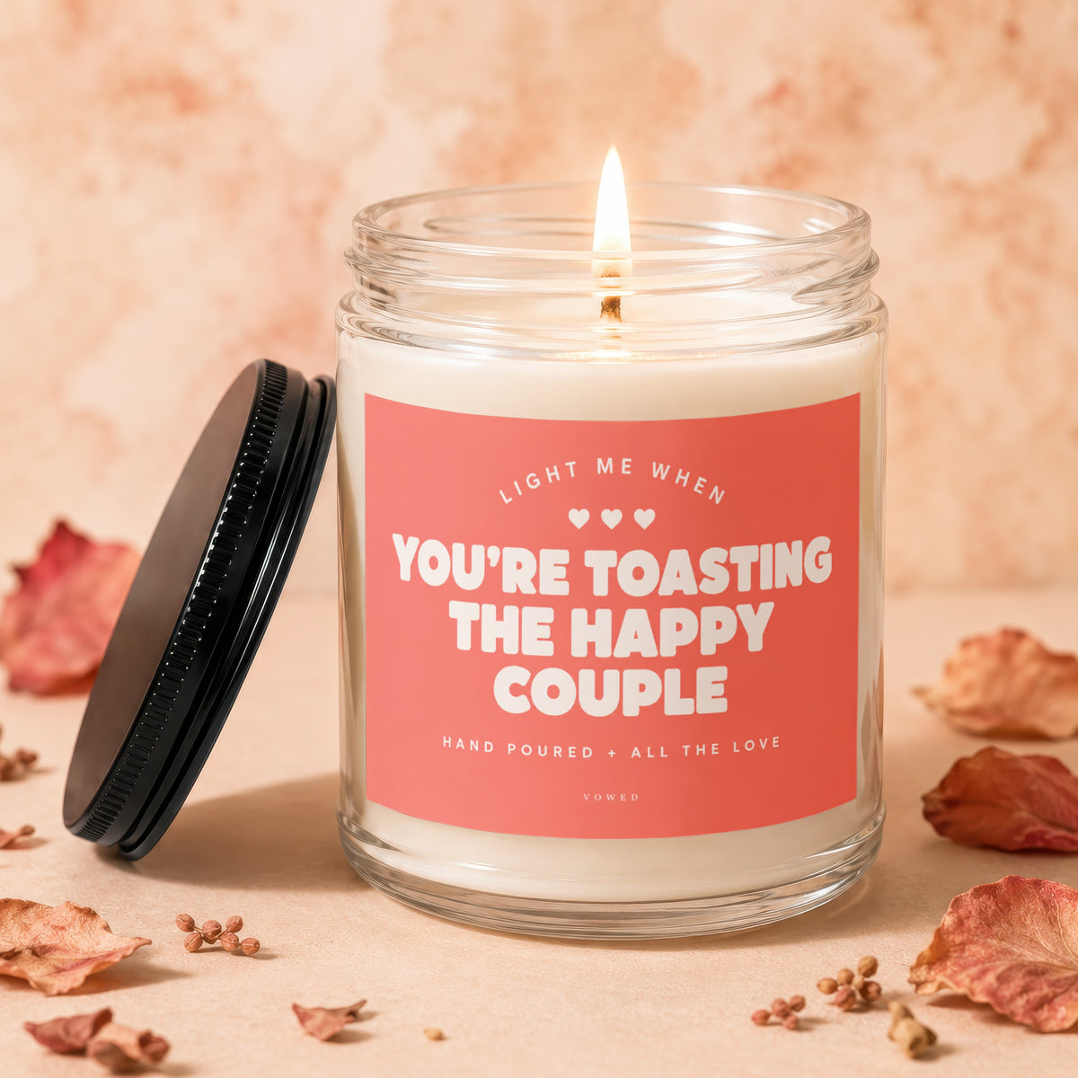 Candle with "You're Toasting The Happy Couple" text and lit wick.