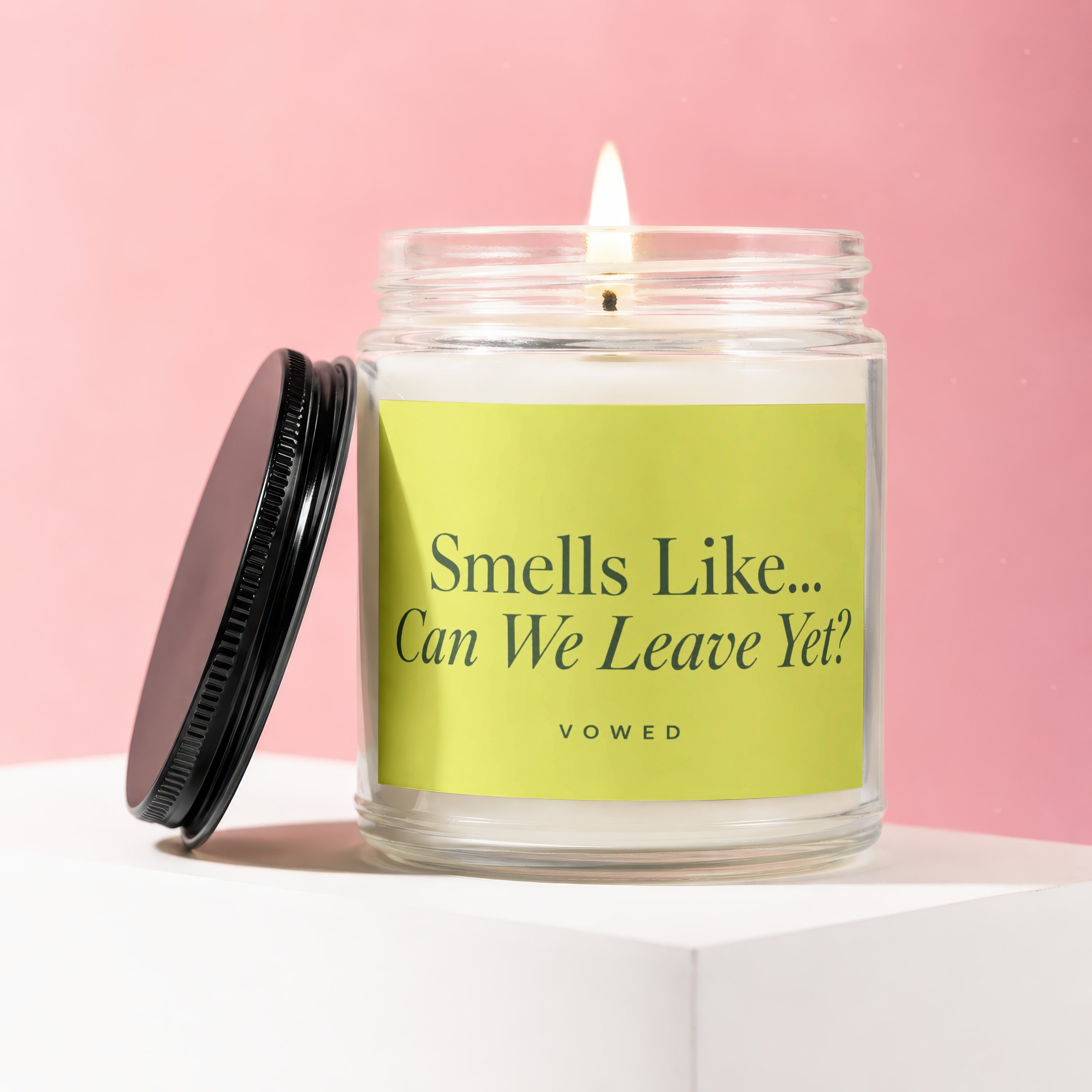 Burning candle in a glass jar with a lime green label reading "Smells Like... Can We Leave Yet?".