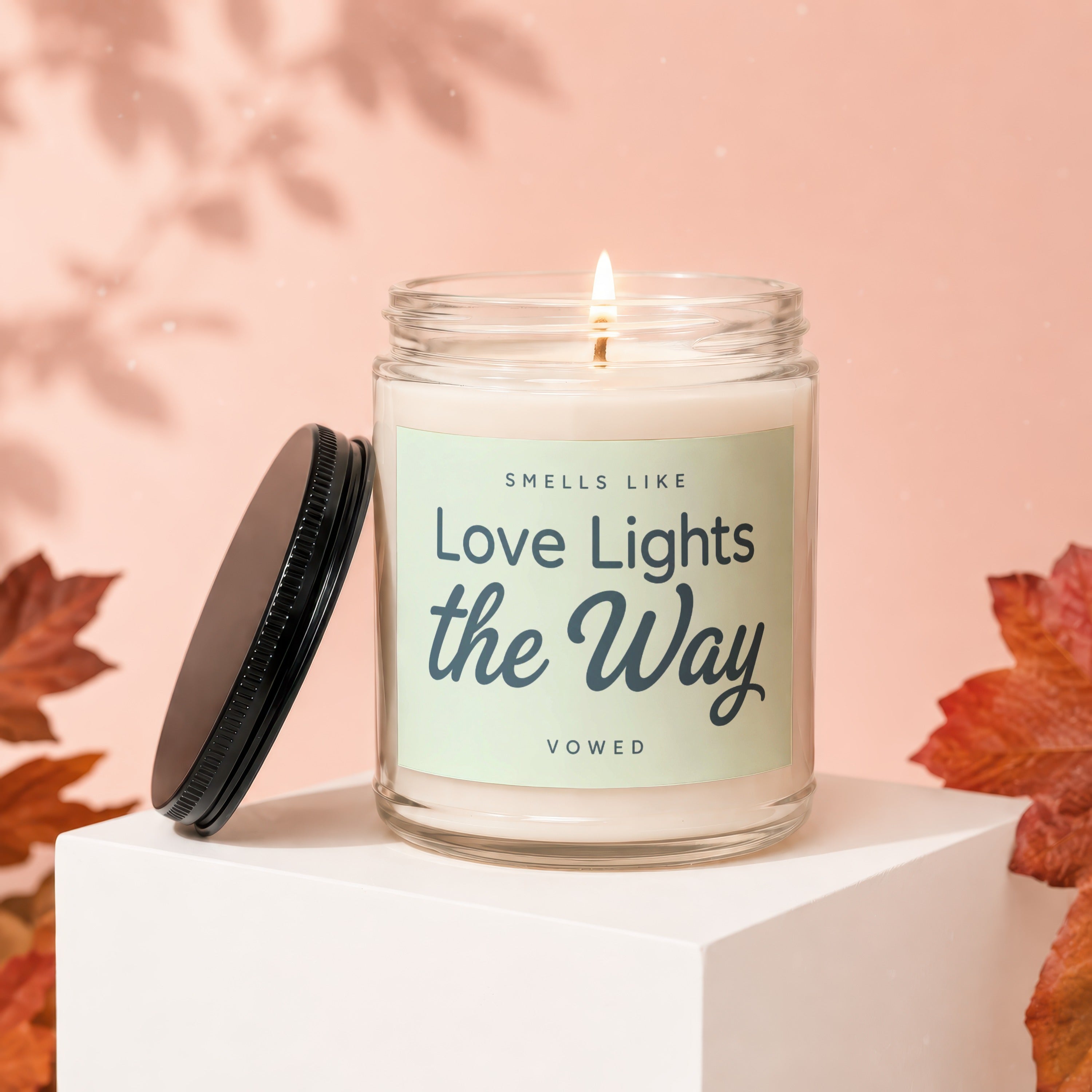 Scented candle with lid off, text reads "Smells Like Love Lights the Way".