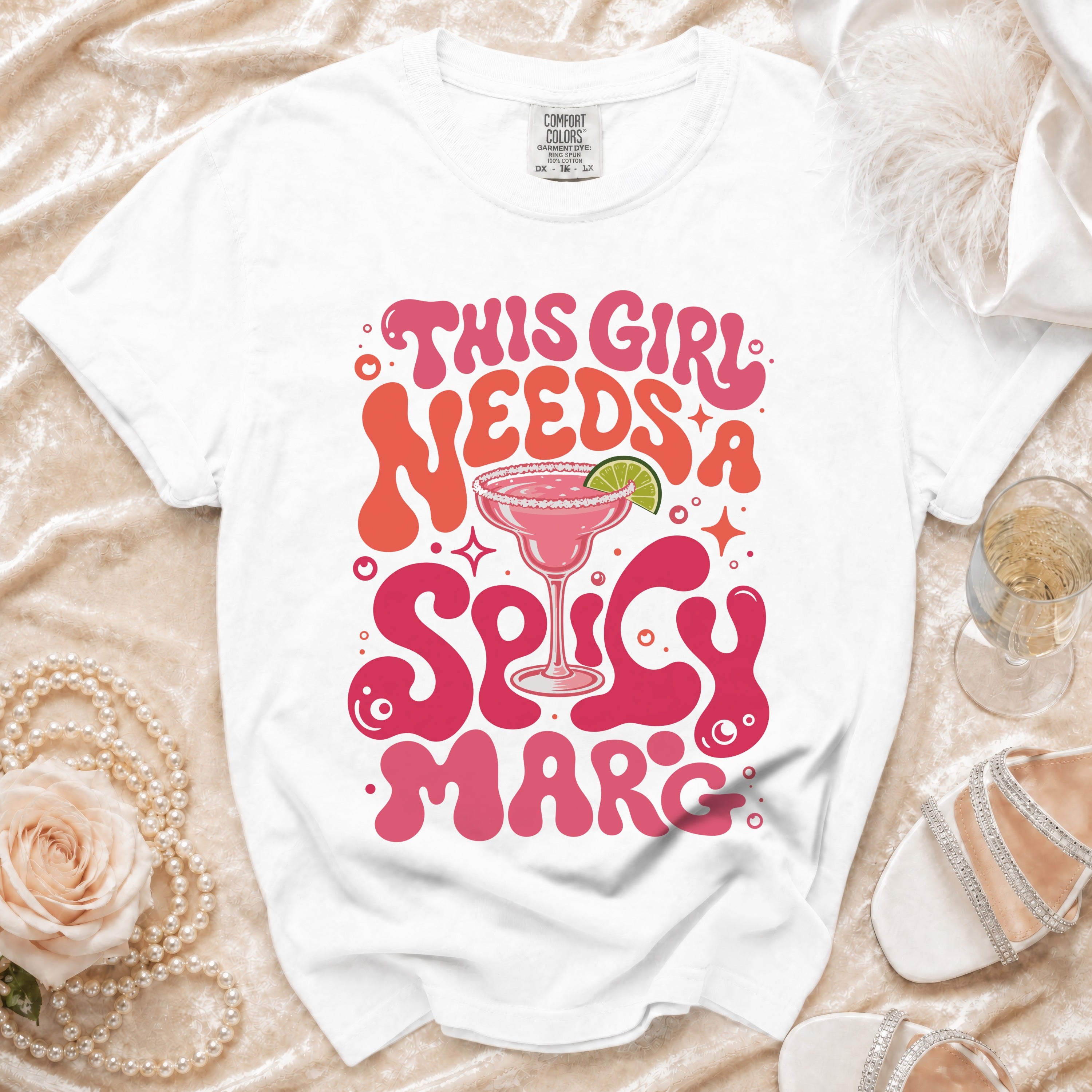 White t-shirt with "This girl needs a spicy marg" graphic and cocktail imagery.