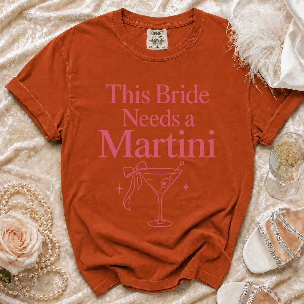 Orange Comfort Colors t-shirt with pink "This Bride Needs a Martini" text and martini glass graphic.