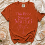 Orange Comfort Colors t-shirt with pink "This Bride Needs a Martini" text and martini glass graphic.