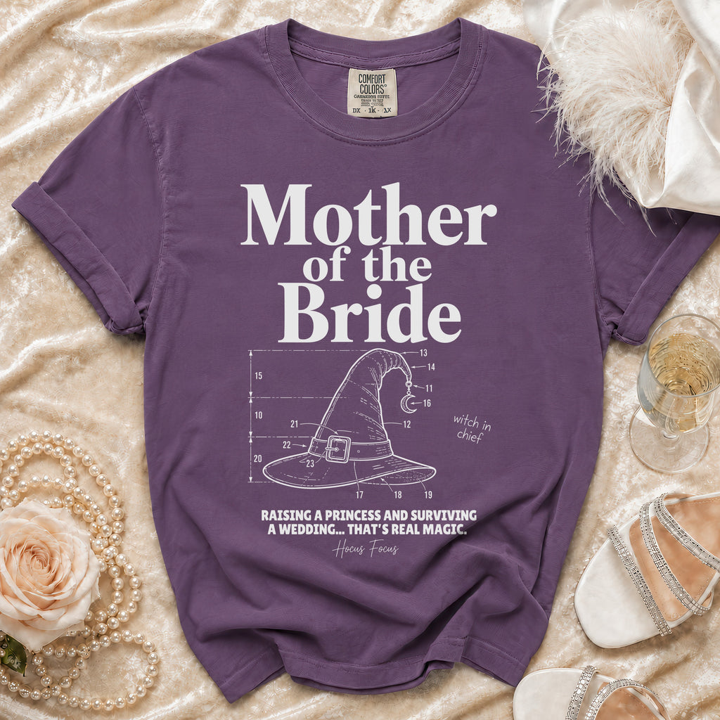 Purple Comfort Colors shirt with "Mother of the Bride" text and witch hat graphic.
